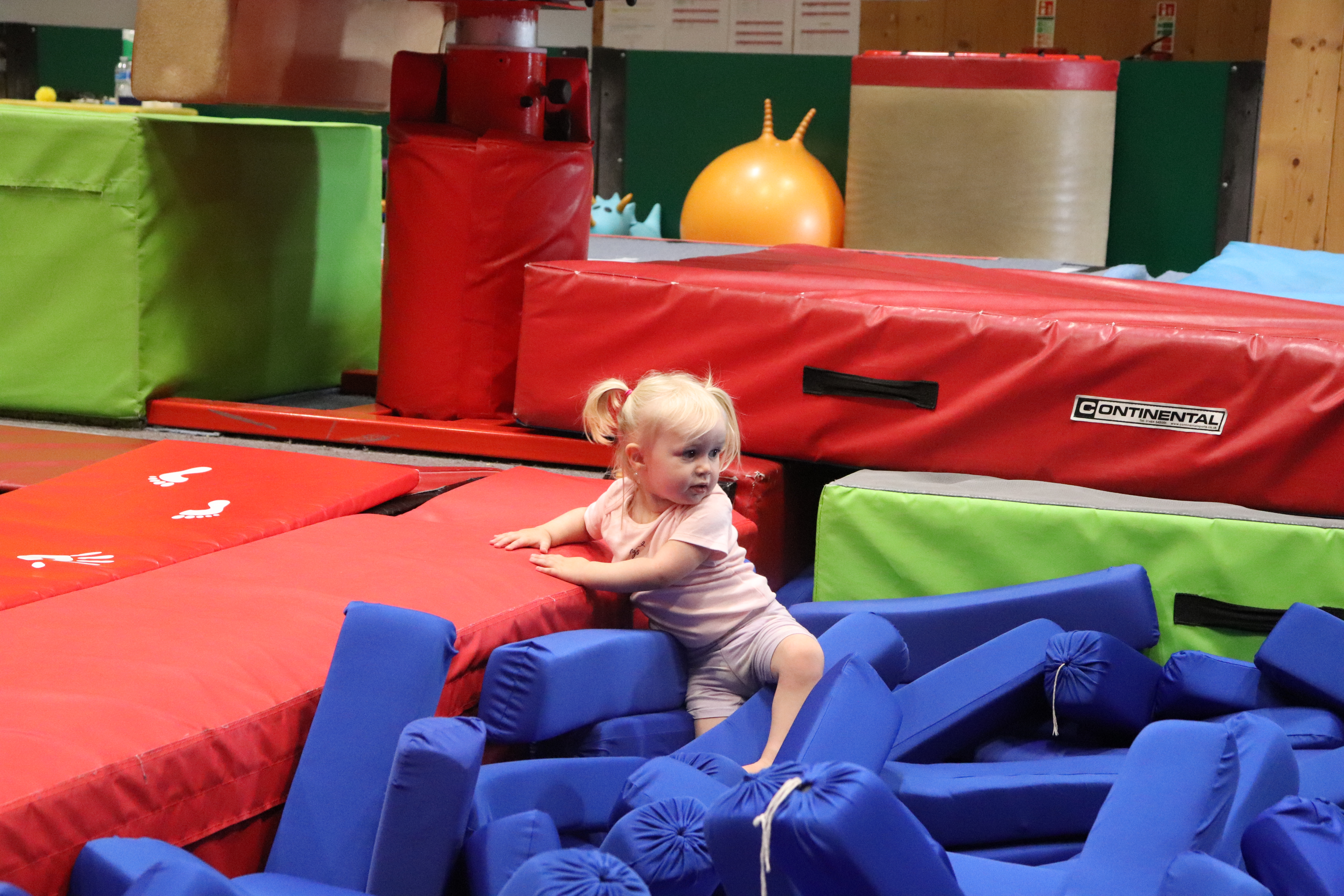 Preschool girl in gymnastics foam pit.