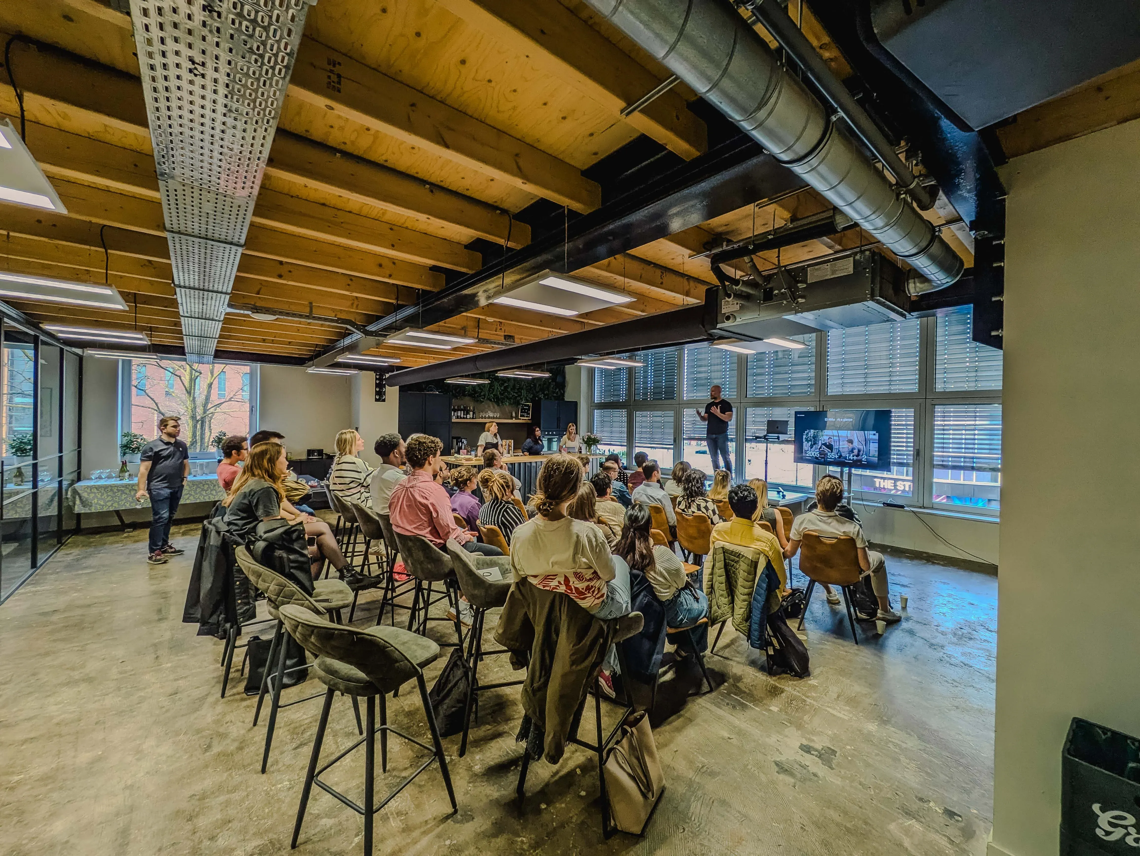 Wide angle image of the audience seated during a presentation at the switching to tech meetup