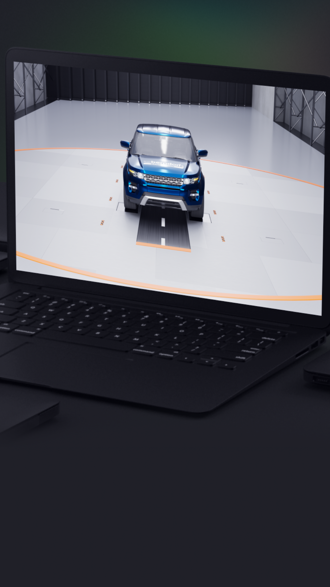 Laptop displaying a 3D model of a blue SUV in a virtual studio setting, surrounded by closed laptops on a dark surface.
