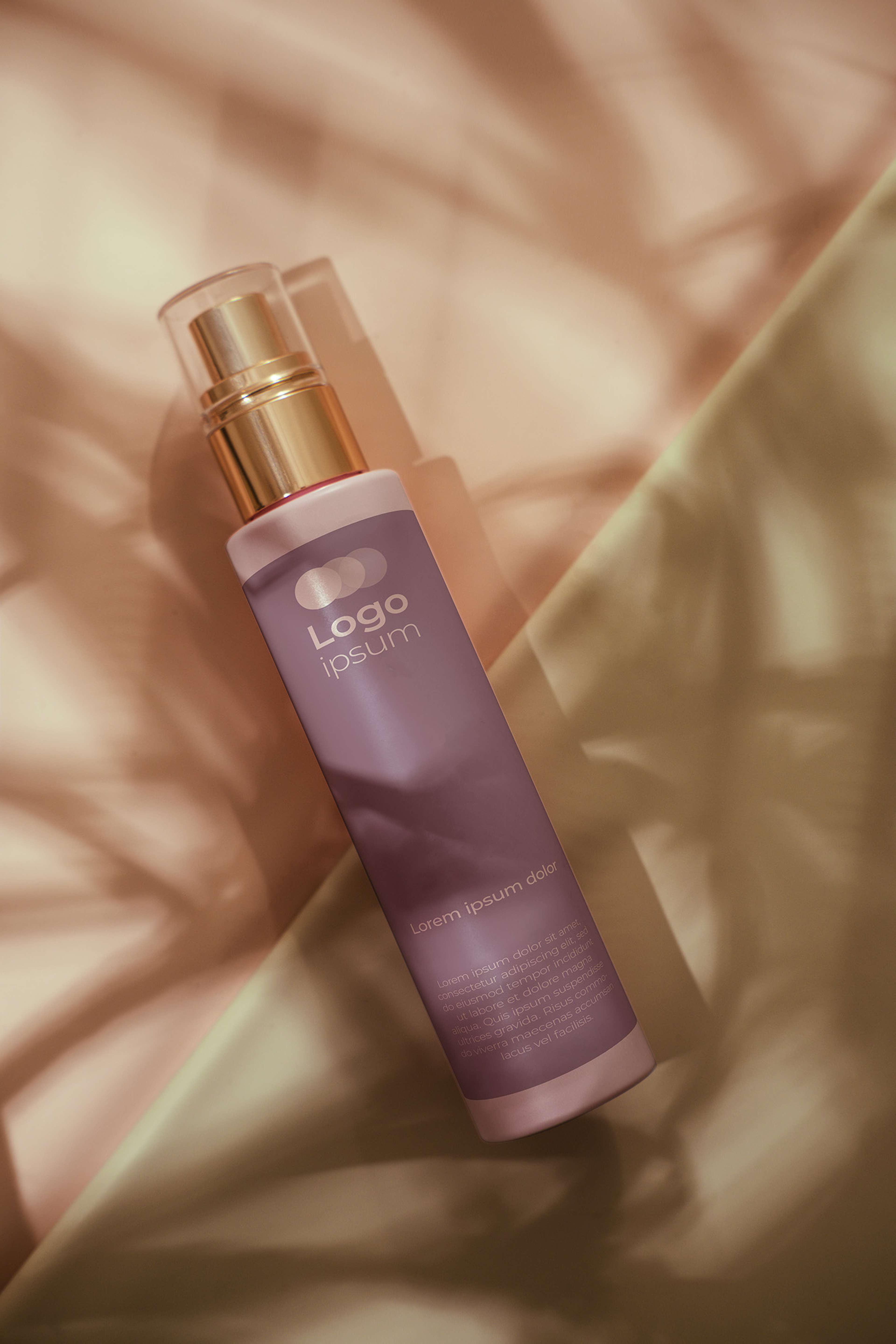 Eine Flasche liegt auf hellem Hintergrund und Blätter werfen Schatten darauf.