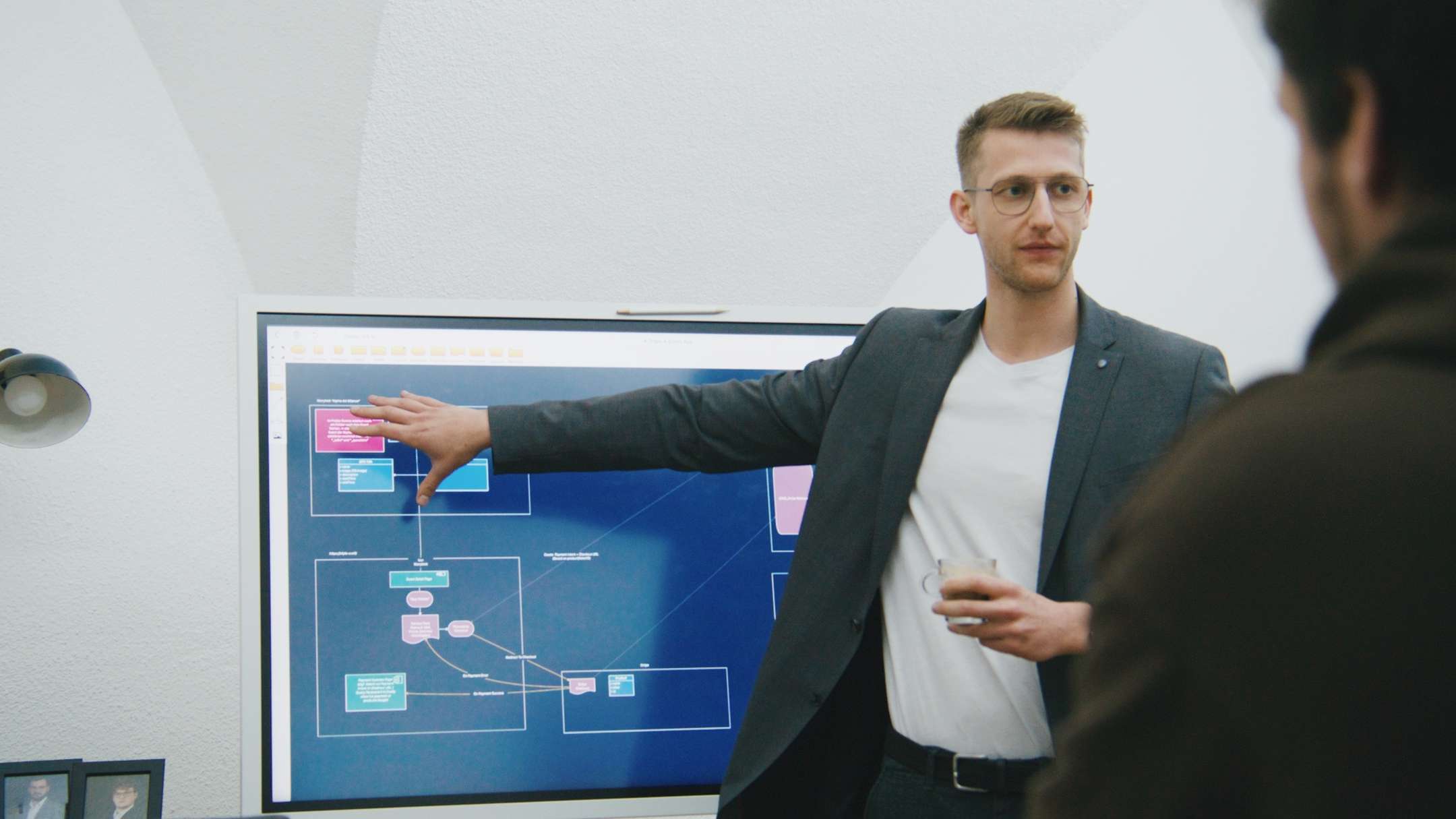 Unser Head of Technical steht vor einem Bildschirm und erklärt Dinge