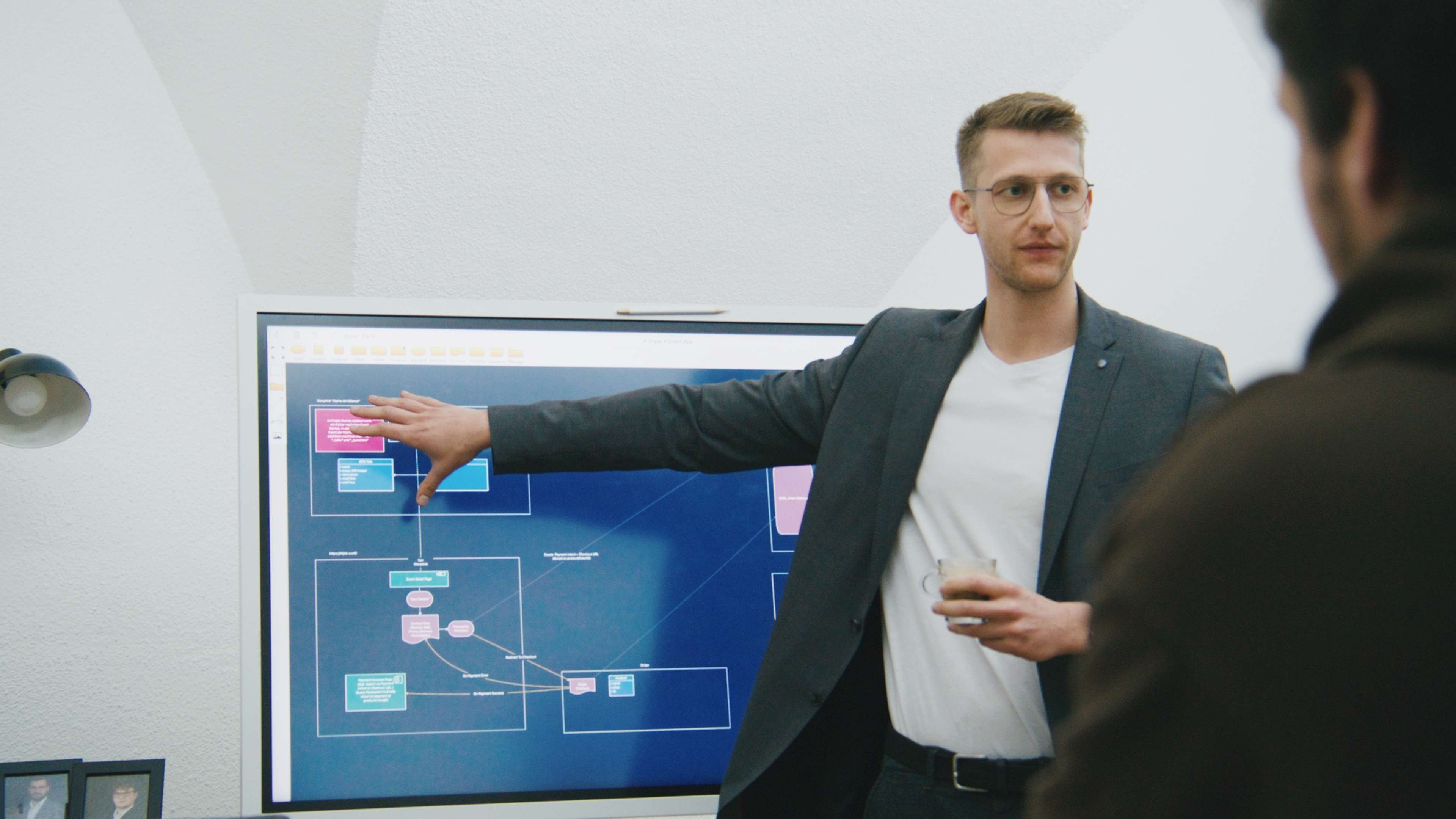 Unser Head of Technical steht vor einem Bildschirm und erklärt Dinge