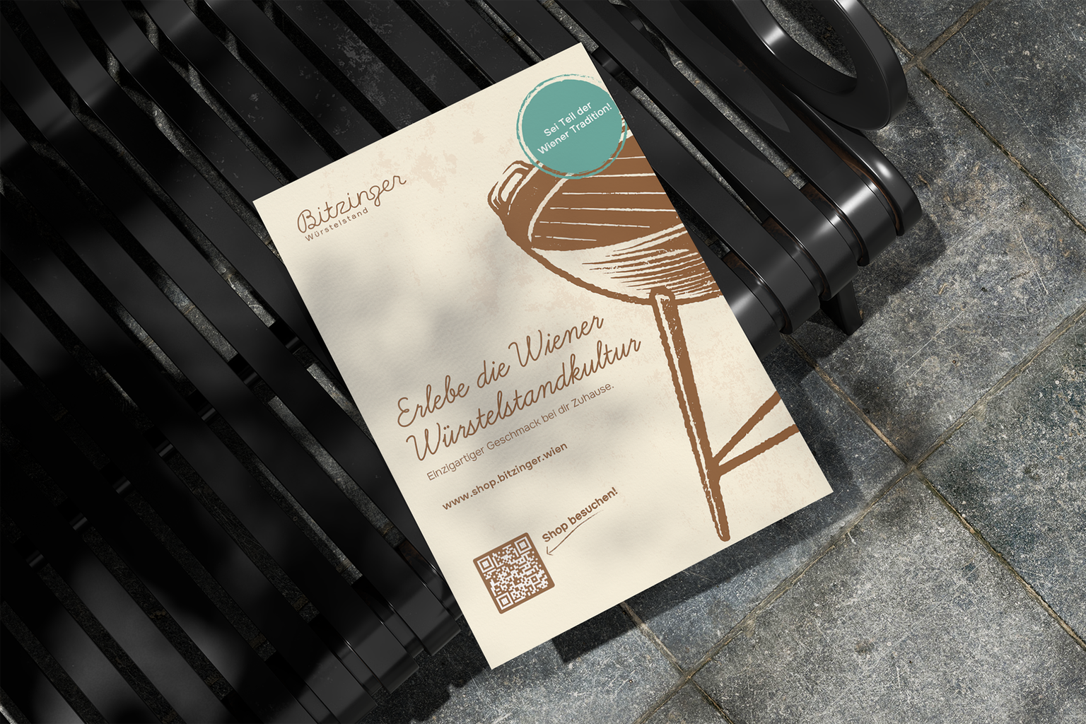 Ein Plakat über den Bitzinger Webshop liegt auf einer Parkbank