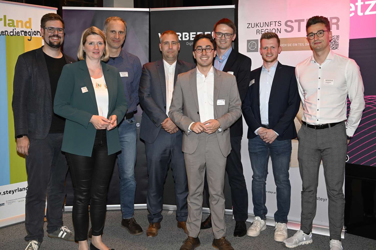 Die Speaker:innen und der Moderator des Hands on Data stehen vor den Veranstaltungsrollups und lächeln in die Kamera.