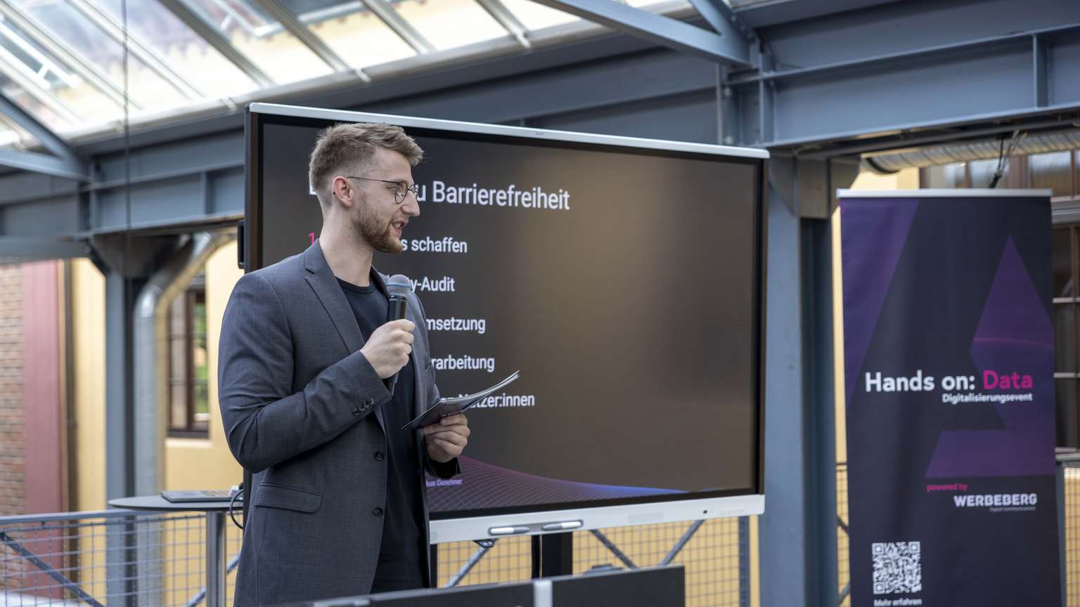 Jemand steht vor einem Bildschirm und präsentiert