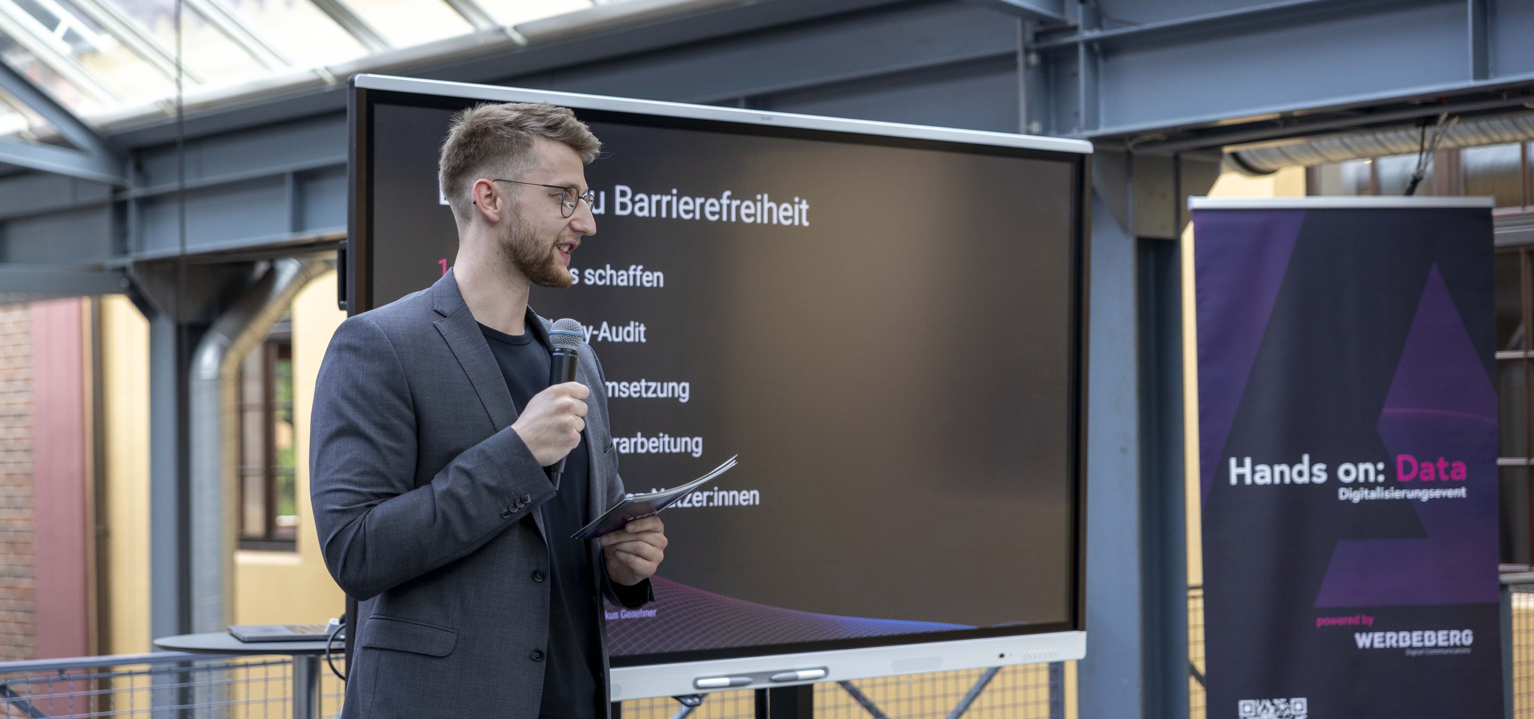 Jemand steht vor einem Bildschirm und präsentiert