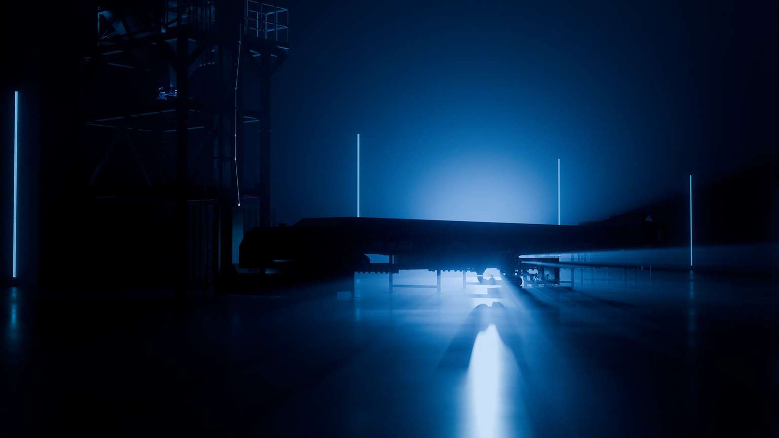 Stahlbandanlage der Berndorf Band Group im Gegenlicht einer dunklen Industriehalle