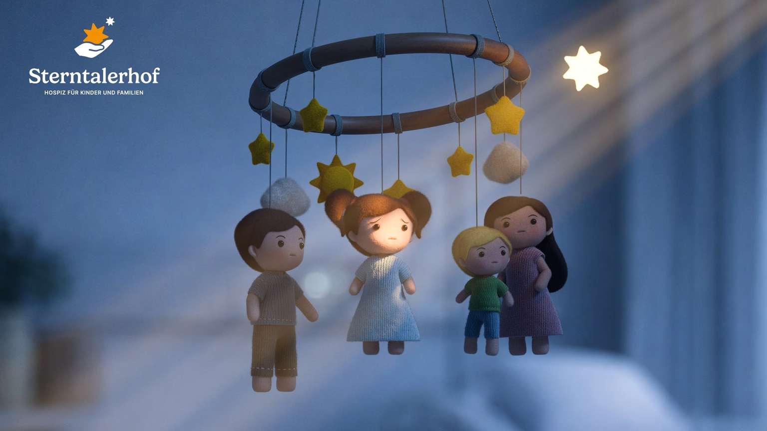 Filz-Mobile mit vierköpfiger Familie im Abendlicht, daneben das Sterntalerhof-Logo