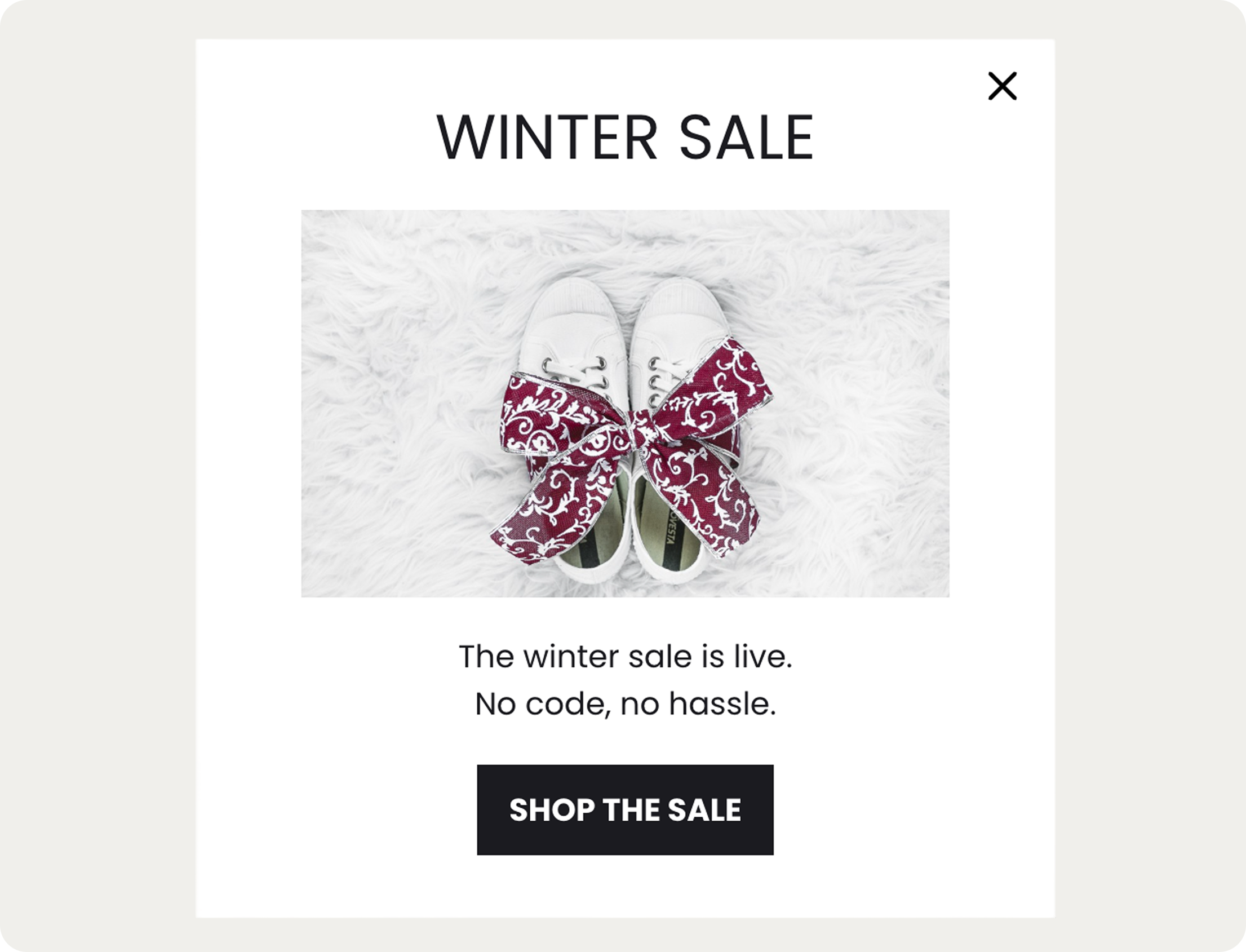 popup with White shoes with red patterned bows on a fluffy surface. Text reads: "Winter Sale. The winter sale is live. No code, no hassle. Shop the sale."