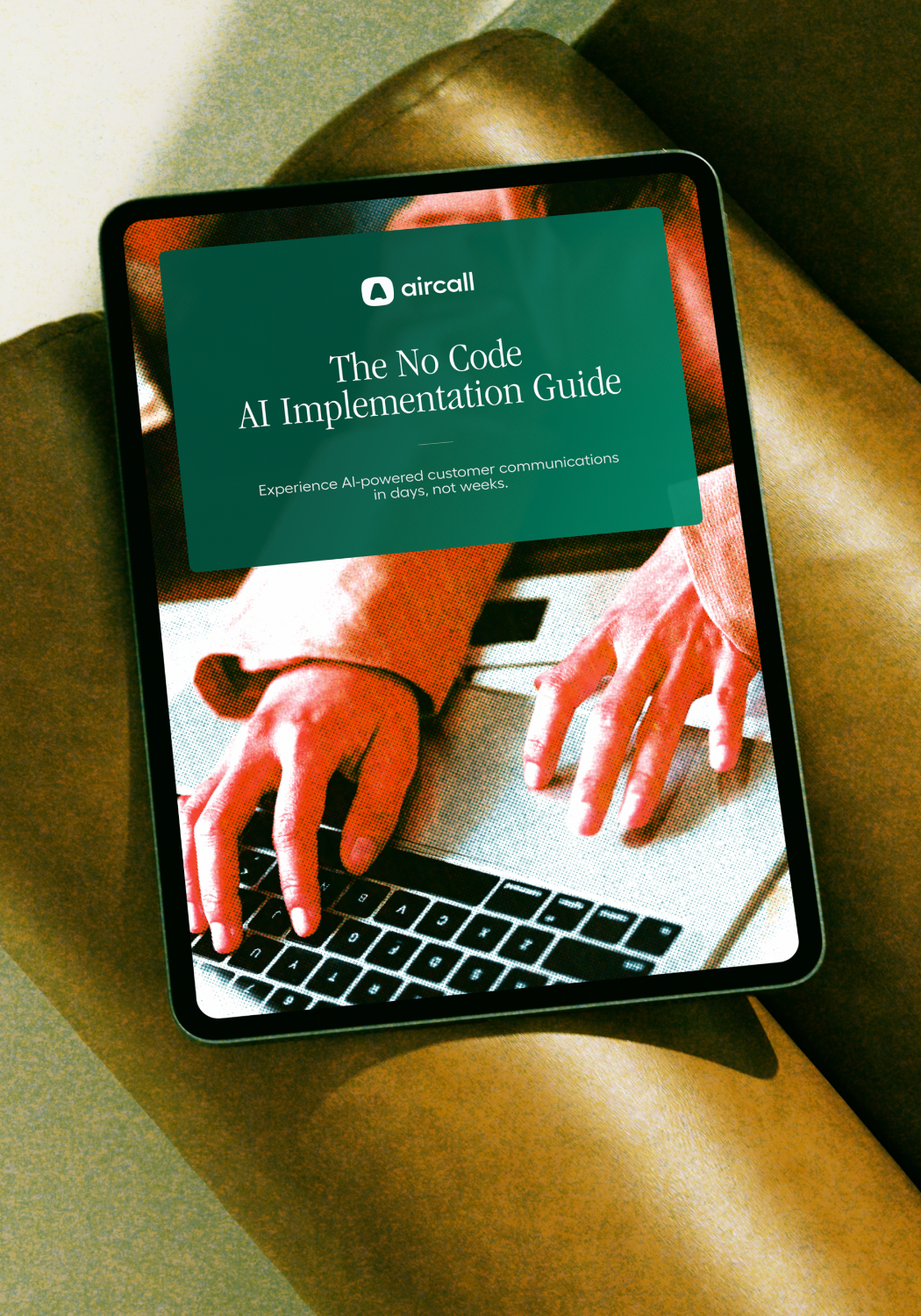 Tablet displaying a guide titled "The No Code AI Implementation Guide," featuring a person's hands typing on a keyboard.