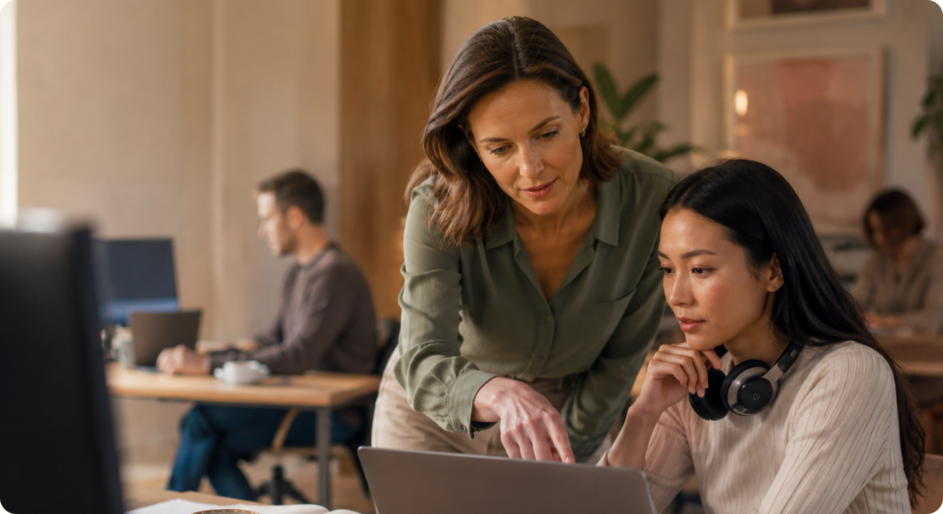 Two colleagues learning at a laptop