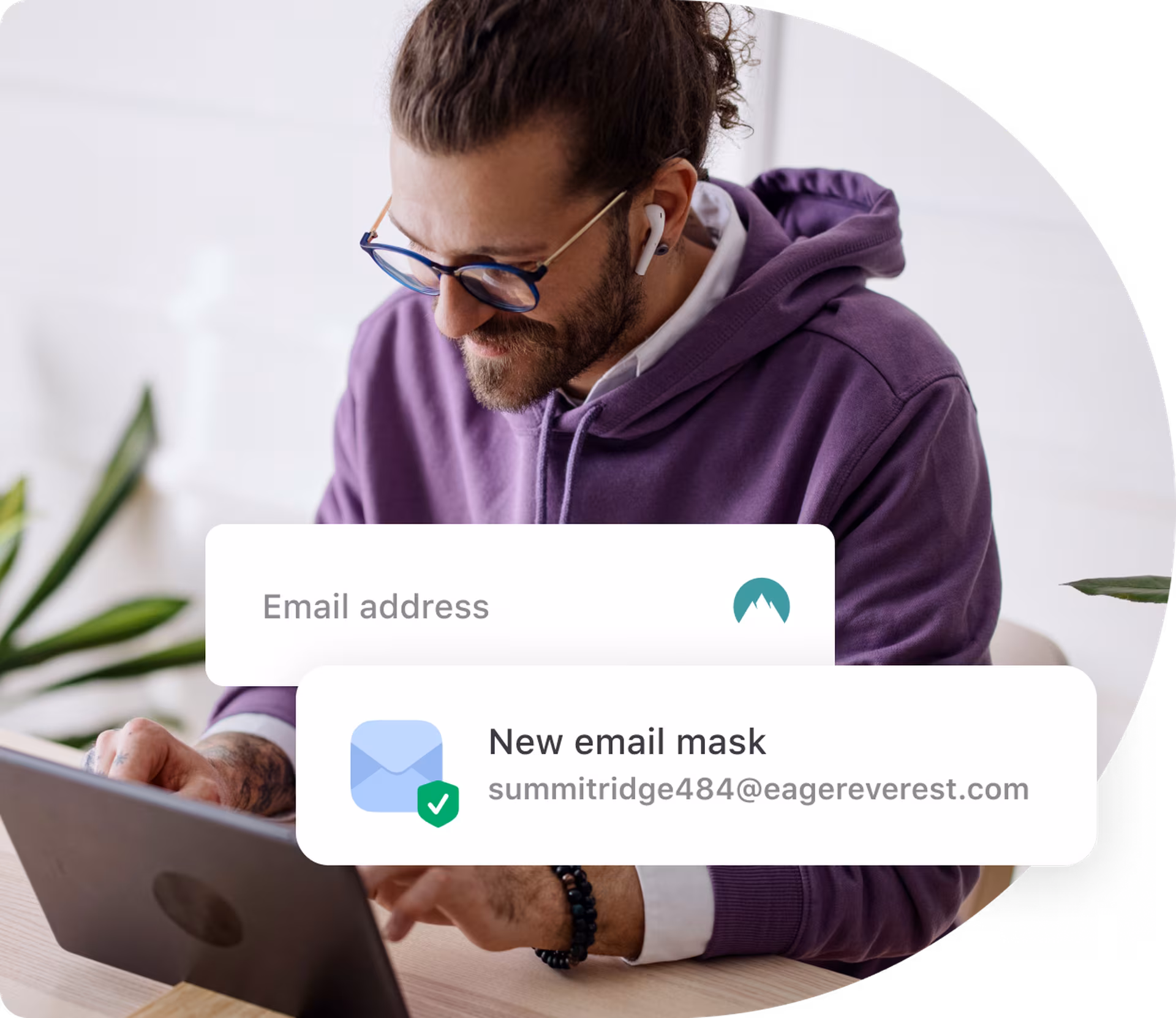 bearded person in purple hoodie using email masking on the laptop
