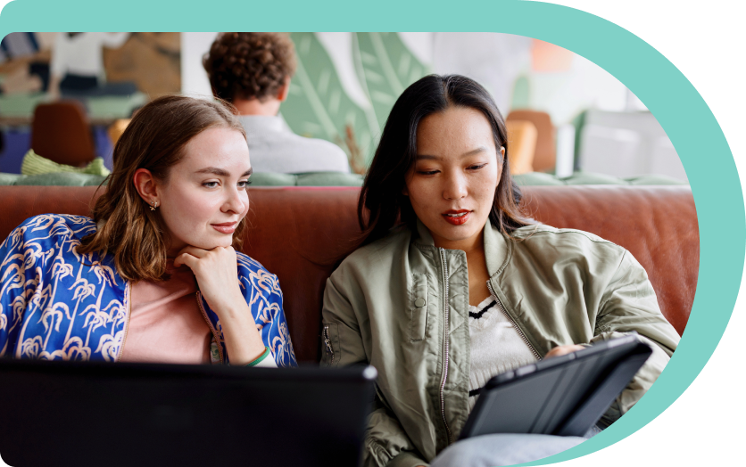 two women on sofa using nordpass on their ipad