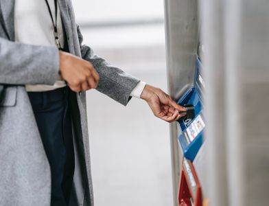 Woman in gray coat withdrawing money from ATM via international-friendly payment