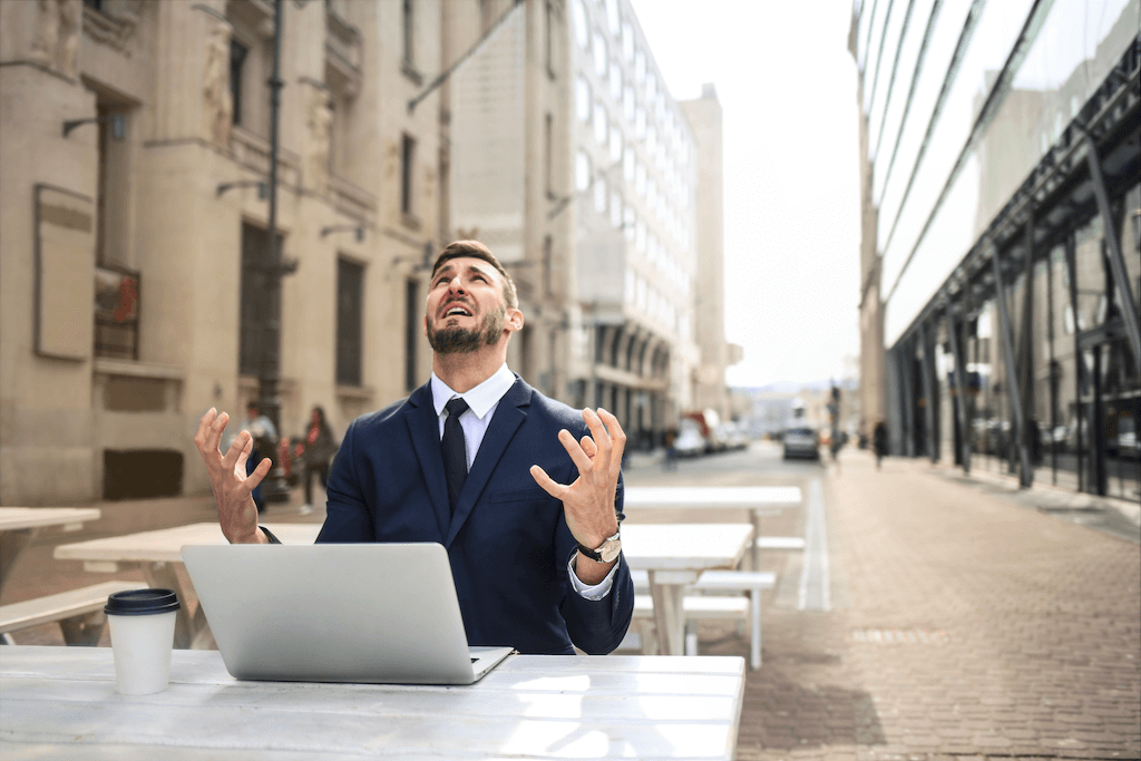 A man looking at the sky in front of a laptop.