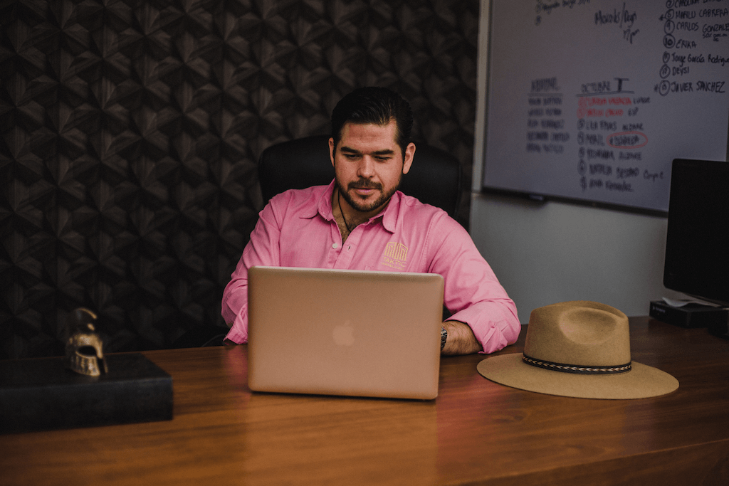 A man typing on a Macbook.