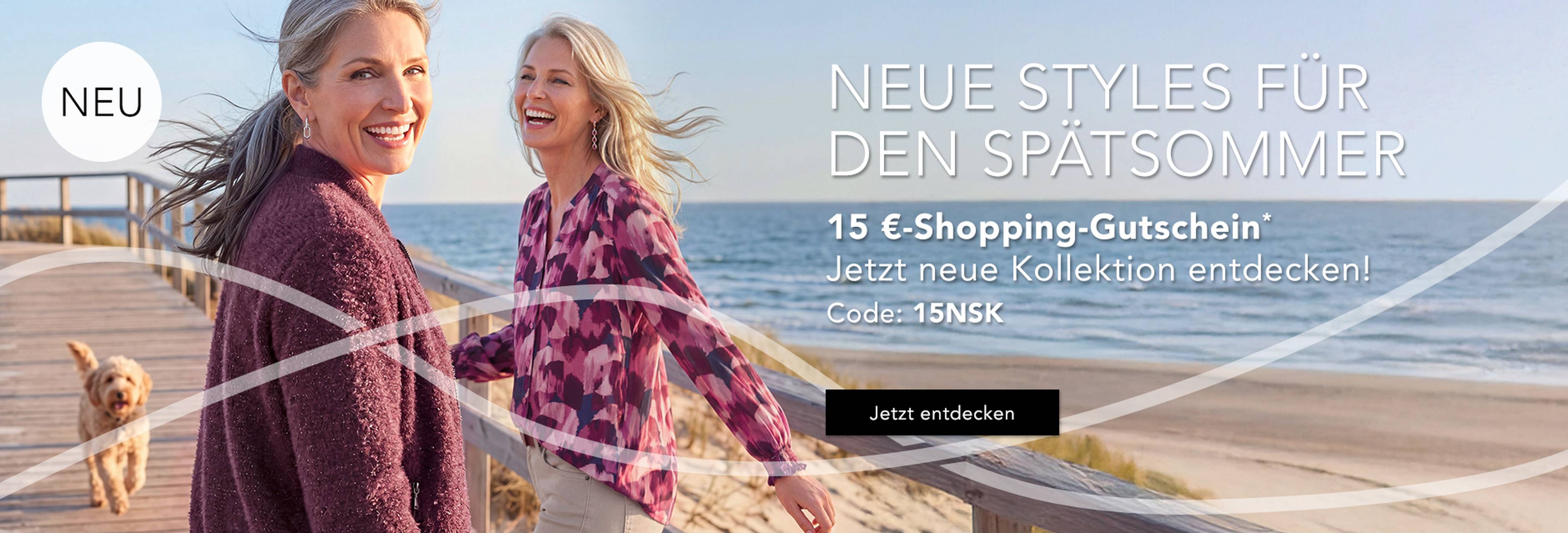  Zwei Frauen spazieren auf einer Strandpromenade in der Nähe des Strandes, lächeln und tragen schicke Outfits. Über dem Bild ist ein Werbetext auf Deutsch eingeblendet.