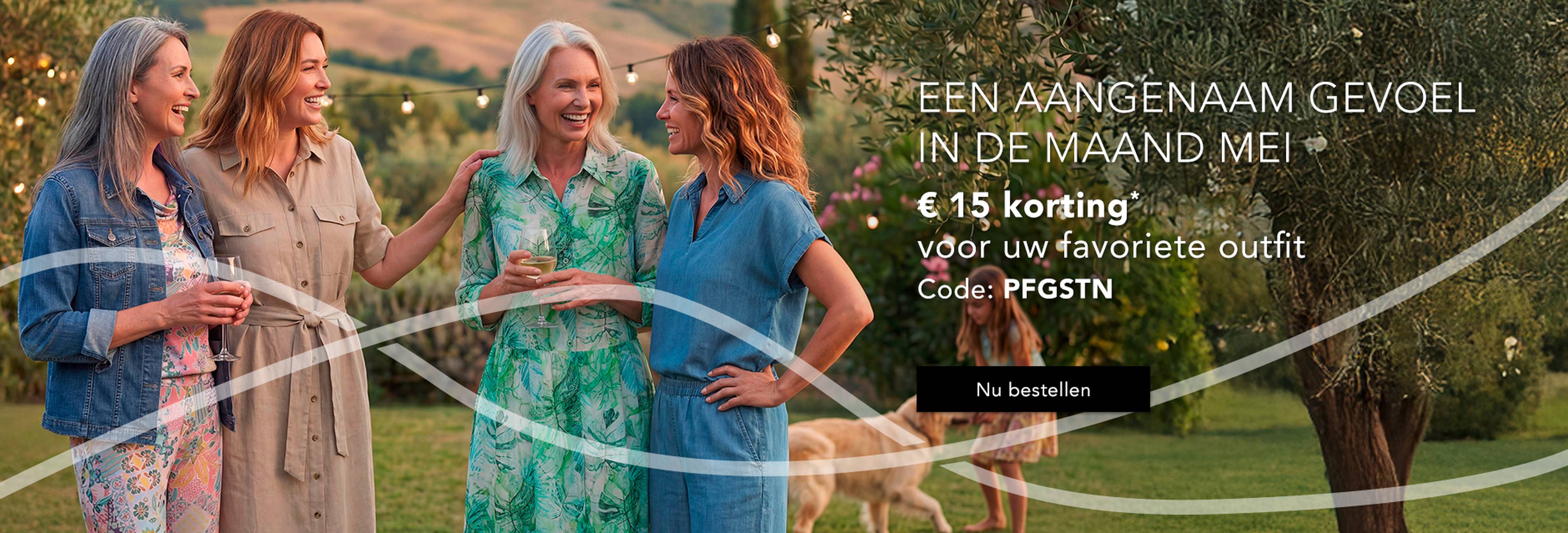  Vier vrouwen staan vrolijk buiten te praten in elegante jurken, omringd door een weelderig landschap. Er zijn aanbiedingen beschikbaar via een kortingscode.