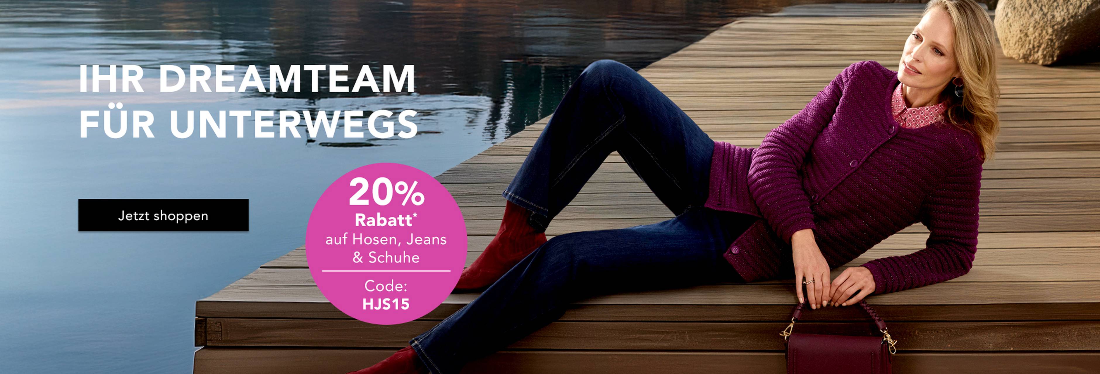 Frau in Jeans und Strickjacke am Seeufer – 20 % Rabatt auf Hosen, Jeans & Schuhe