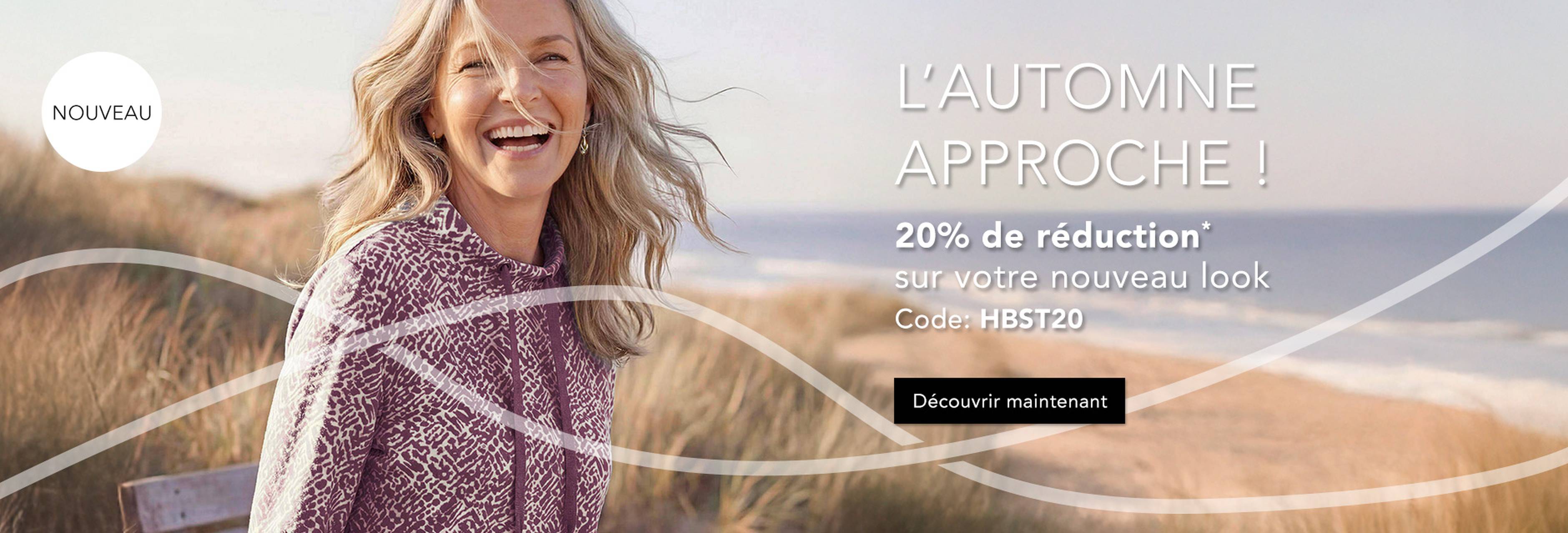 Femme souriante en pull douillet sur la plage, avec un texte annonçant les soldes d'automne et 20 % de réduction avec un code promo.
