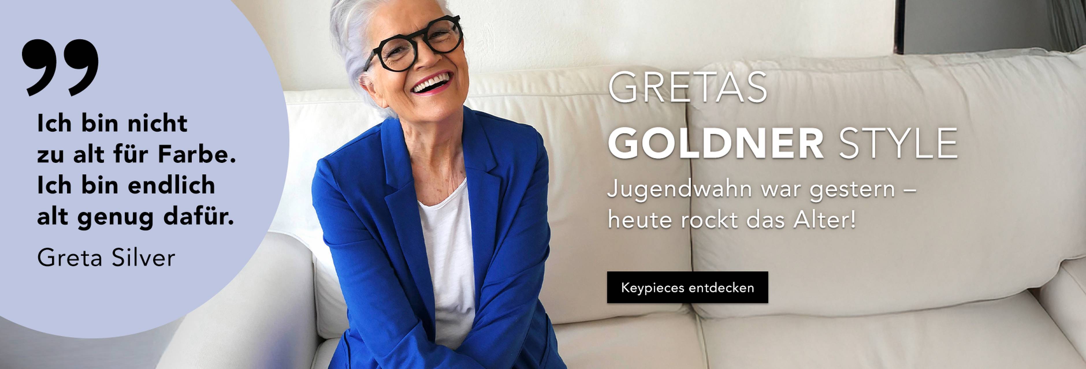 Lächelnde Frau mit grauen Haaren und Brille, die einen blauen Blazer trägt und auf einem weißen Sofa sitzt. Der Text vermittelt Selbstbewusstsein in Bezug auf Alter und Stil und wirbt für Kleidung, welche von Greta Silver empfohlen wird.