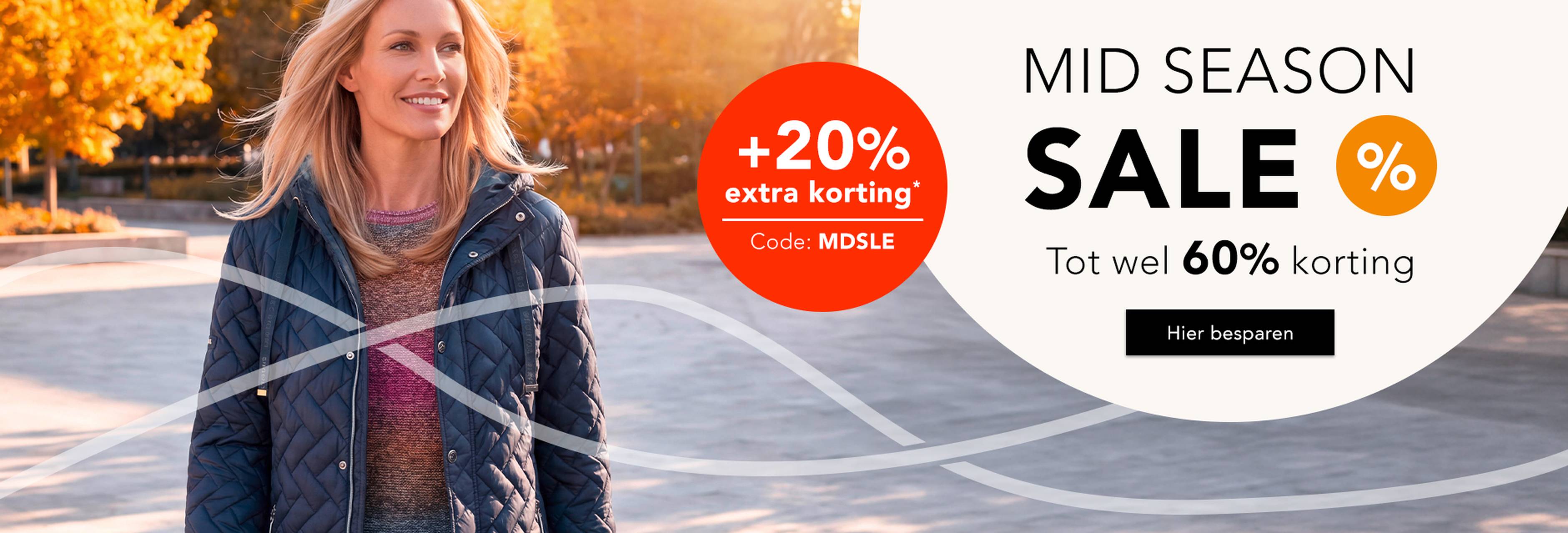 Vrouw in een herfstachtige omgeving draagt een elegant jasje. Mid Season Sale met tot wel 60% korting. Actie met +20% extra korting.