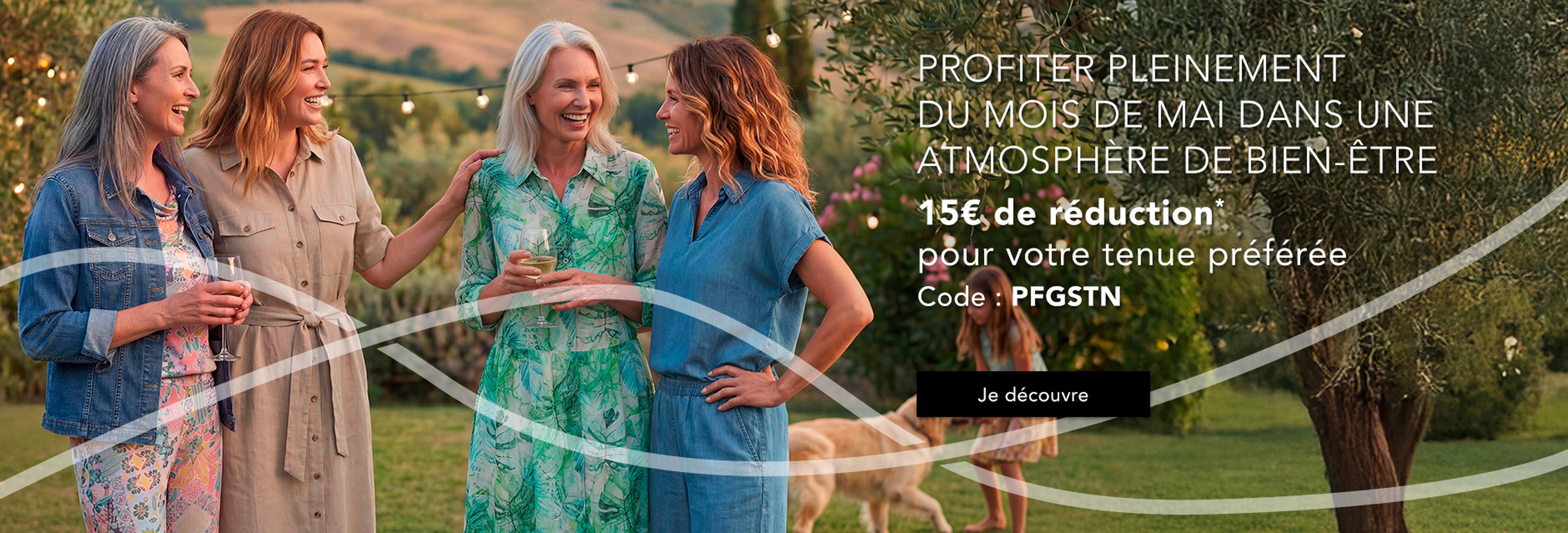  Quatre femmes vêtues d'élégantes robes discutent joyeusement en plein air, au milieu d'un paysage luxuriant. Des offres sont disponibles via un code de réduction.