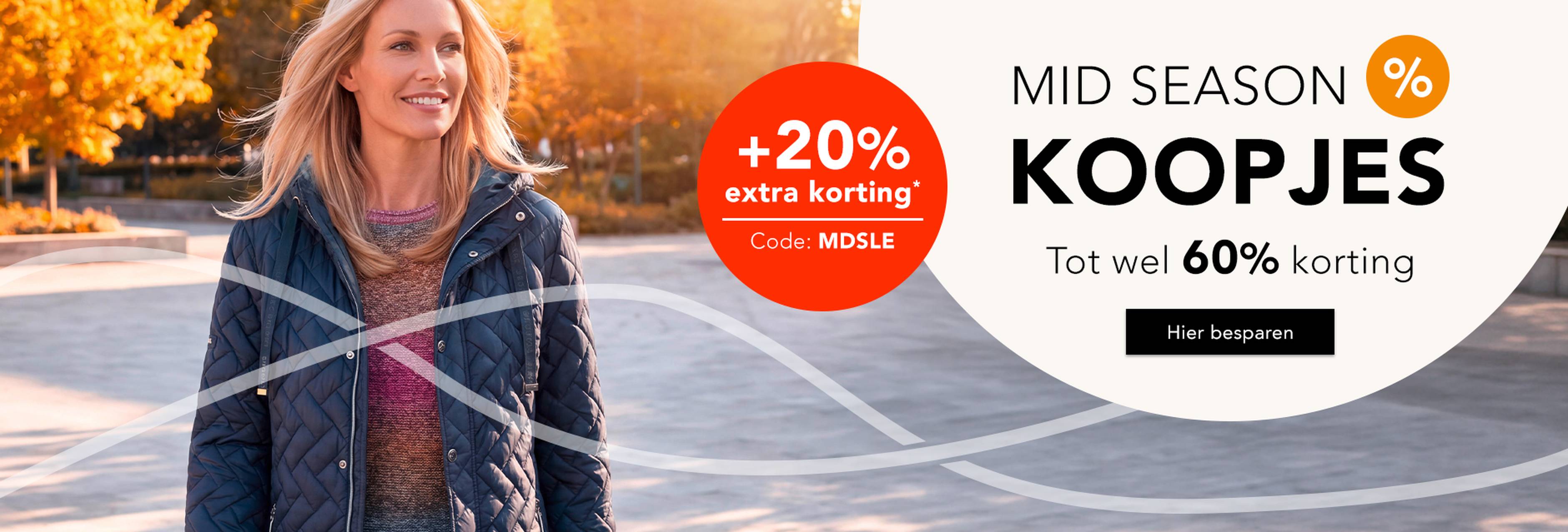 Vrouw in een herfstachtige omgeving draagt een elegant jasje. Mid Season Sale met tot wel 60% korting. Actie met +20% extra korting.