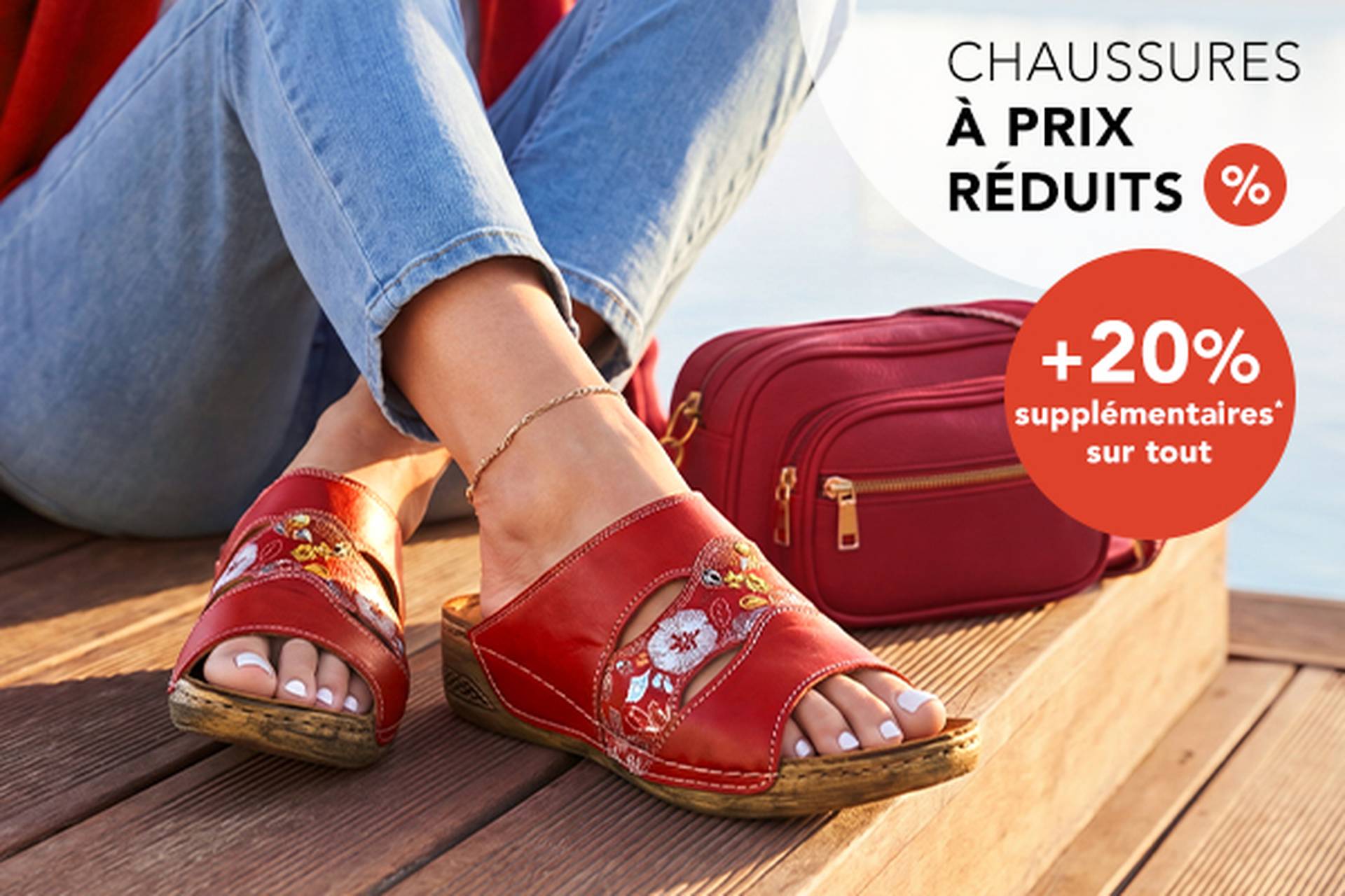  Une femme portant des sandales rouges à motifs floraux, assise près d'un sac à main rouge. Légende : soldes sur les chaussures jusqu'à 70 % de réduction et 20 % de réduction supplémentaire.
