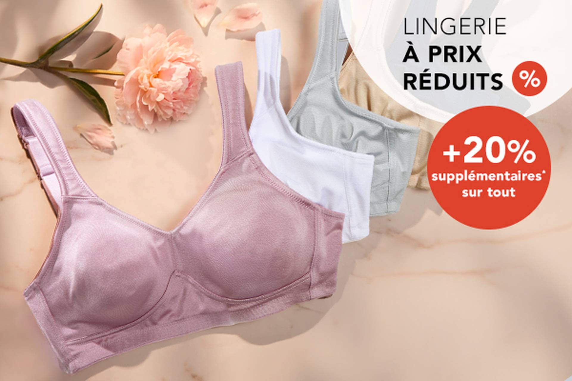  Trois soutiens-gorge aux couleurs douces posés sur une surface, accompagnés d'une fleur. Le texte promotionnel met en avant des réductions allant jusqu'à 70 % et une remise supplémentaire de 20 %.