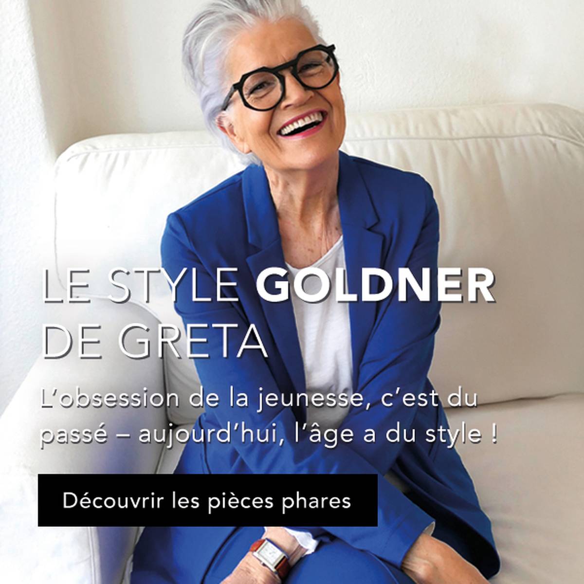Femme souriante aux cheveux gris, portant des lunettes et un blazer bleu, assise sur un canapé blanc. Le texte transmet une assurance liée à l'âge et au style et fait la promotion de vêtements recommandés par Greta Silver.