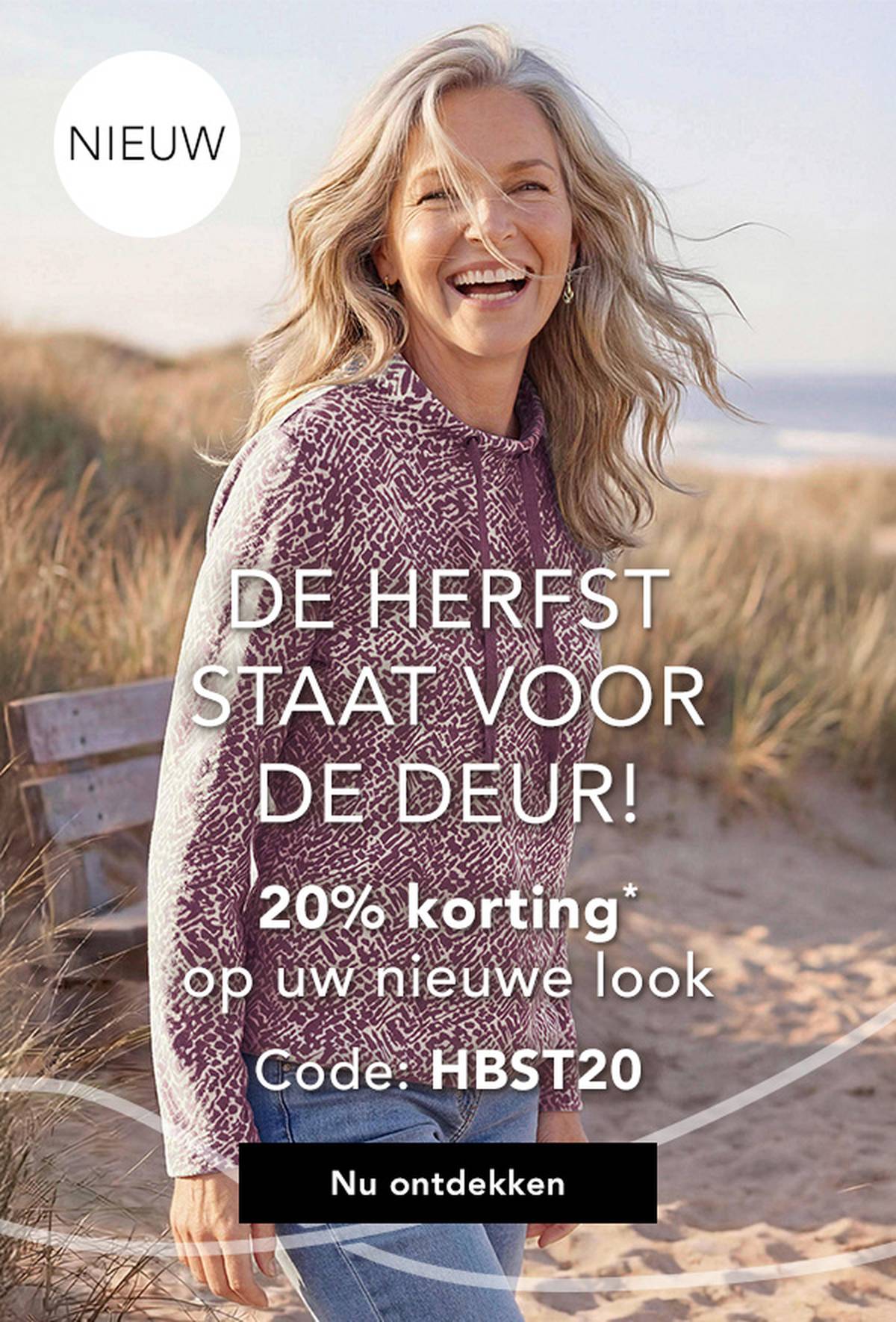 Glimlachende vrouw in een zachte trui op het strand, met daarbij een tekst die reclame maakt voor een herfstuitverkoop met 20% korting bij gebruik van een actiecode.