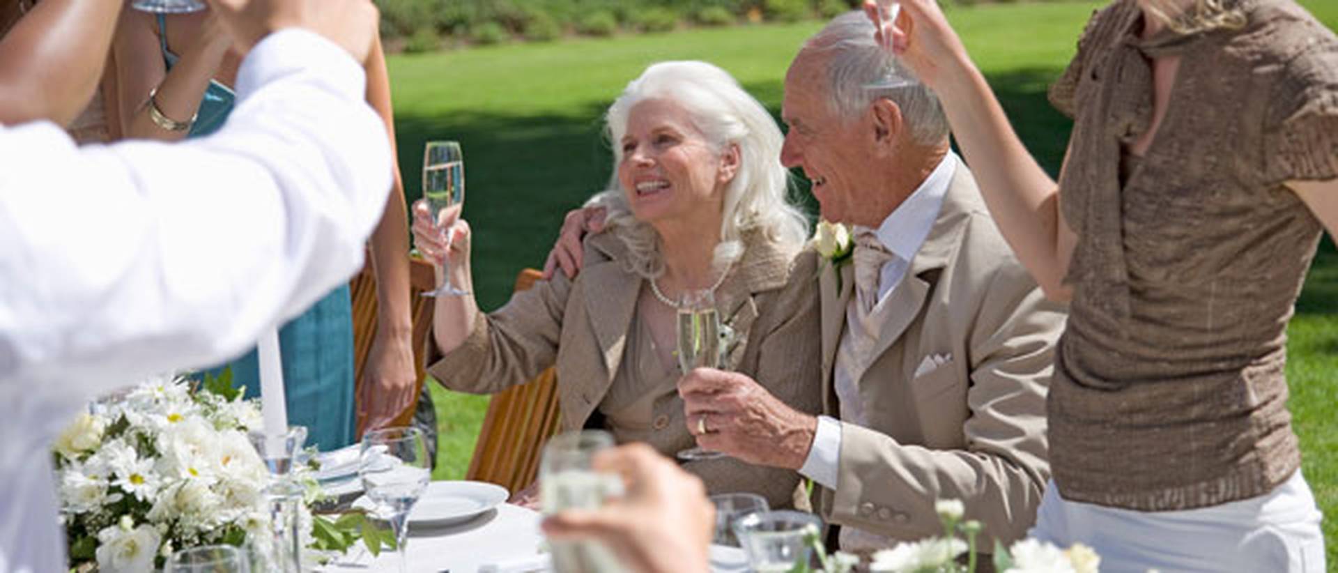 Brautmutter und Brautvater sprechen einen Toast und heben die Gläser