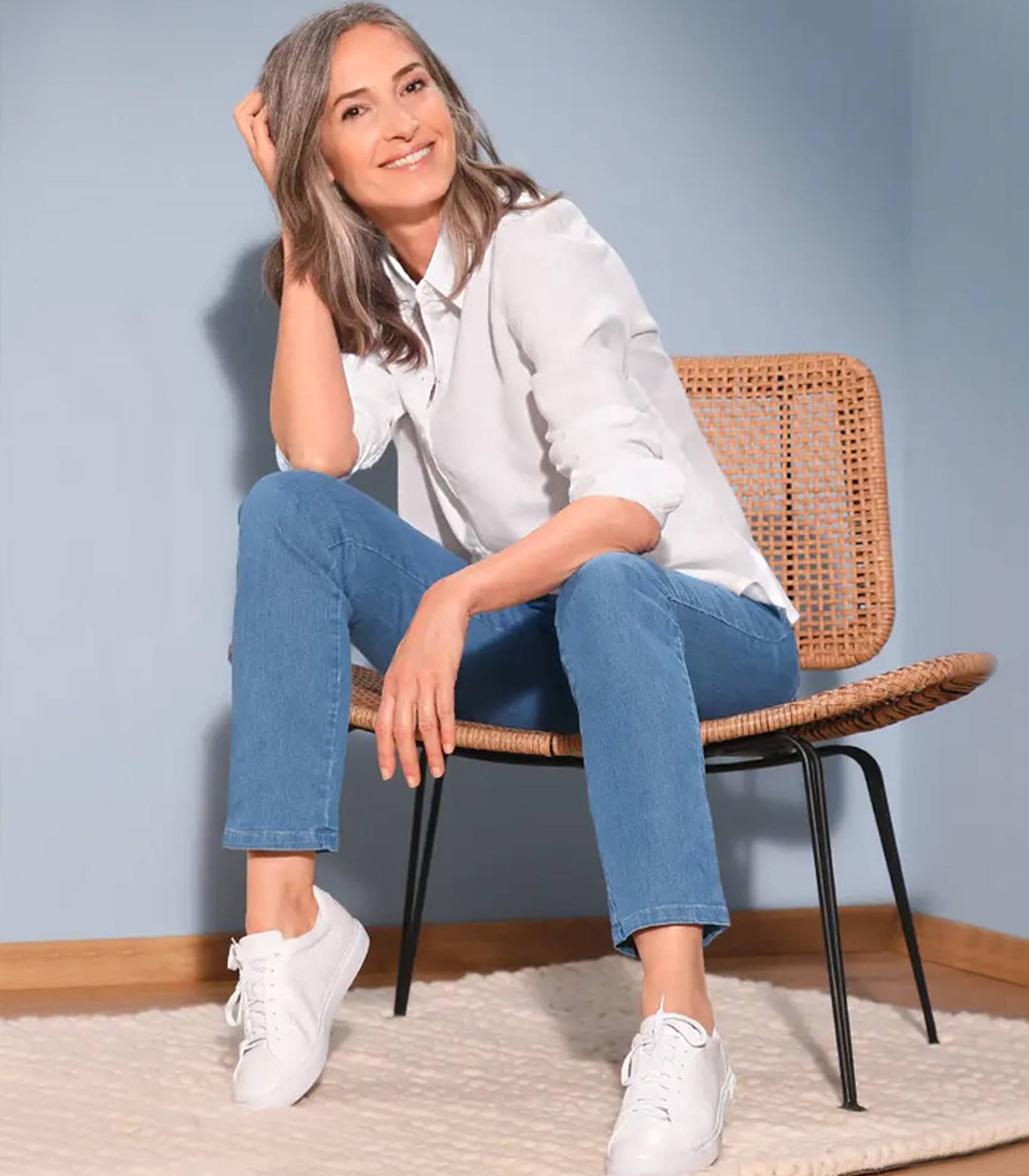 Ontdek korte pagina - Vrouw op een stoel met blauwe jeans en witte blouse