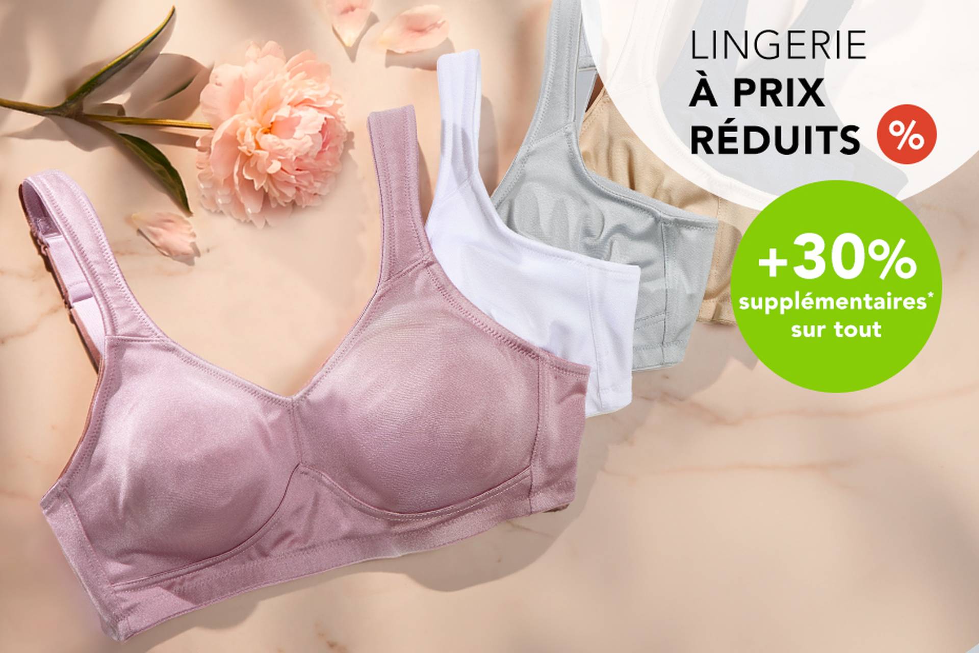  Trois soutiens-gorge aux couleurs douces posés sur une surface, accompagnés d'une fleur. Le texte promotionnel met en avant des réductions allant jusqu'à 70 % et une remise supplémentaire de 20 %.