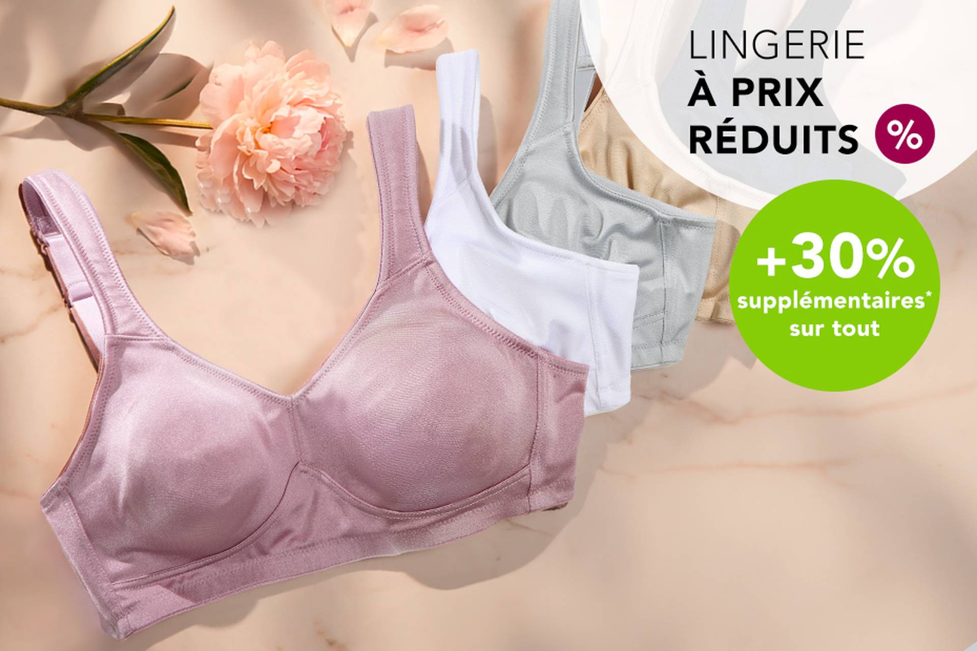  Trois soutiens-gorge aux couleurs douces posés sur une surface, accompagnés d'une fleur. Le texte promotionnel met en avant des réductions allant jusqu'à 70 % et une remise supplémentaire de 20 %.