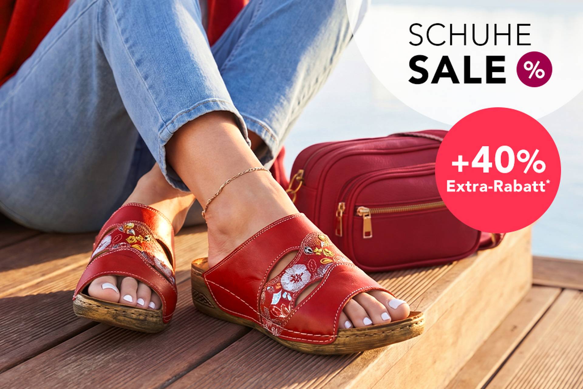  Eine Frau in roten Sandalen mit Blumenmuster sitzt neben einer roten Handtasche. Bildunterschrift: Schuhausverkauf mit bis zu 70 % Rabatt und zusätzlichen 40 % Rabatt.
