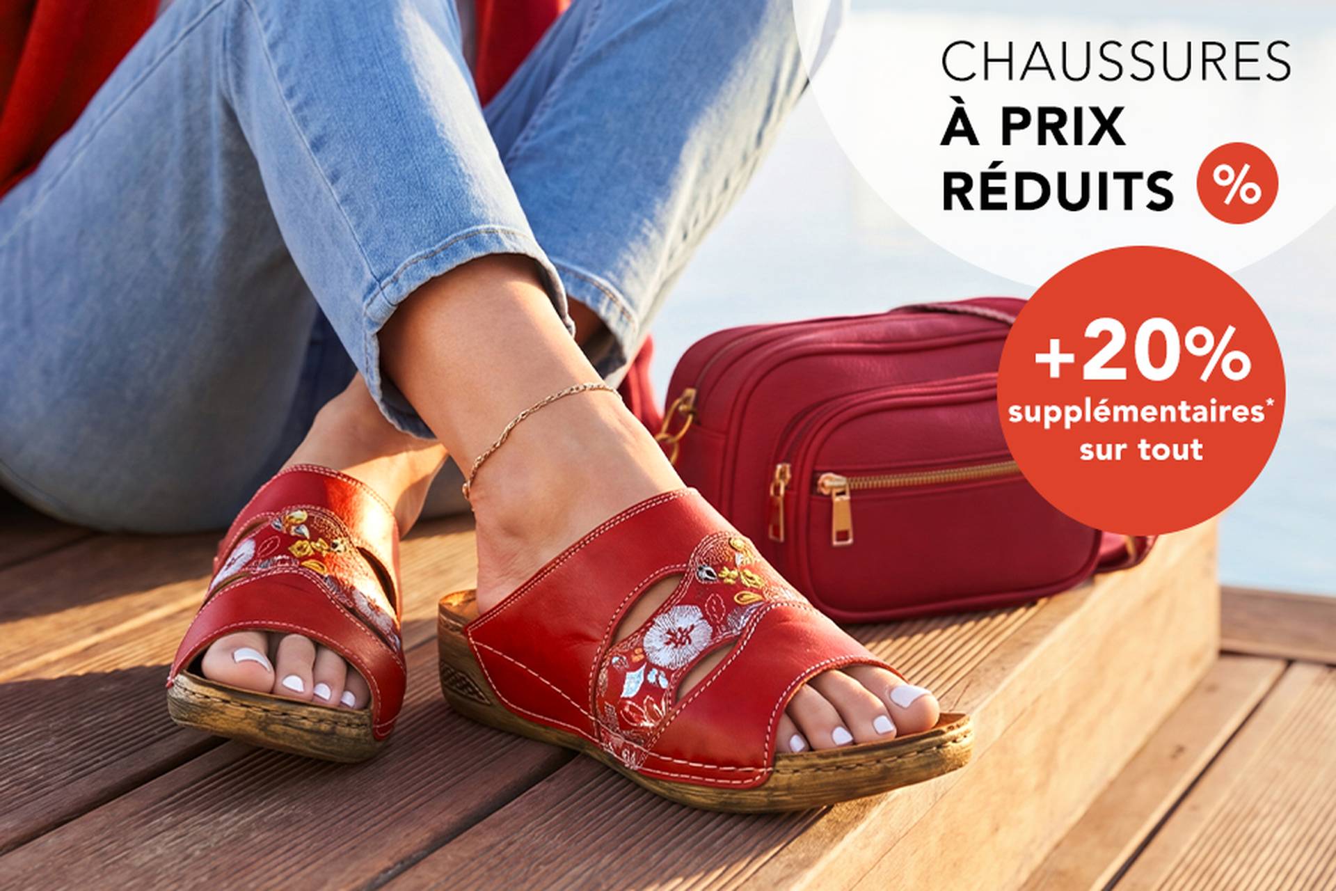 Une femme portant des sandales rouges à motifs floraux, assise près d'un sac à main rouge. Légende : soldes sur les chaussures jusqu'à 70 % de réduction et 20 % de réduction supplémentaire.