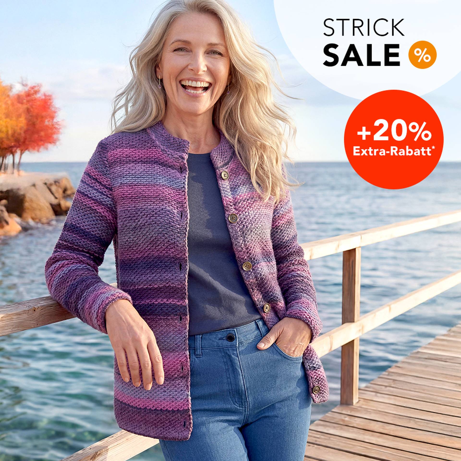 Ältere Frau in lila-gestreifter Strickjacke lächelt auf einem Steg am Wasserrand. Text: "Strick SALE +20% Extra-Rabatt".