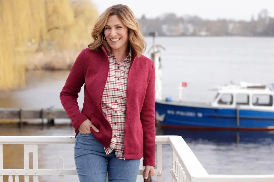 Femme avec une veste rouge au bord du lac