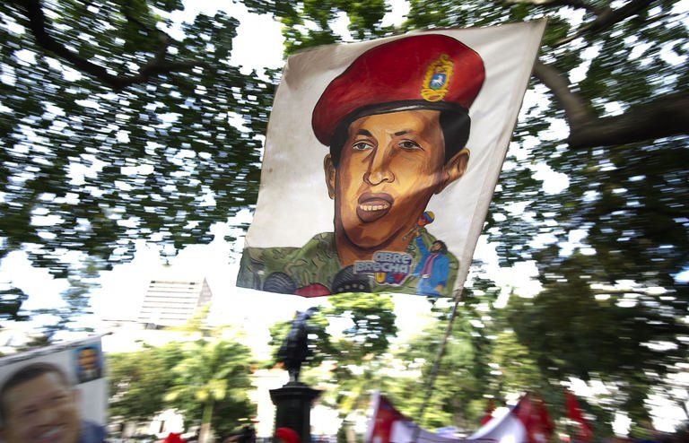 Un partidario del presidente venezolano exhibe una bandera con su retrato el 9 de diciembre de 2012 en Caracas  © AFP Juan Barreto