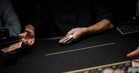 A person dealing cards at a poker table in the middle of a poker tournament