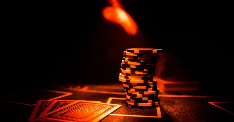 Một chồng chip đặt trên những lá bài rải rác