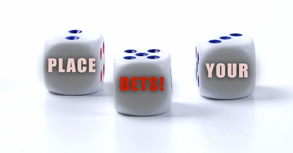 Three white dice with blue pips. Text on dice reads "PLACE YOUR BETS!" in pink and red letters.