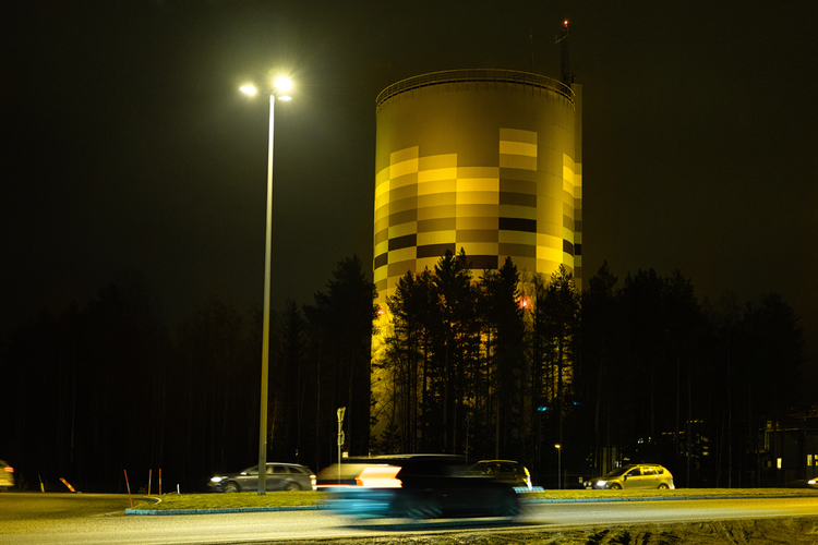 Umeå Energis anläggning Graniten (panncentral för fjärrvärme och fjärrkyla på Ålidhem) upplyst i gult/guld