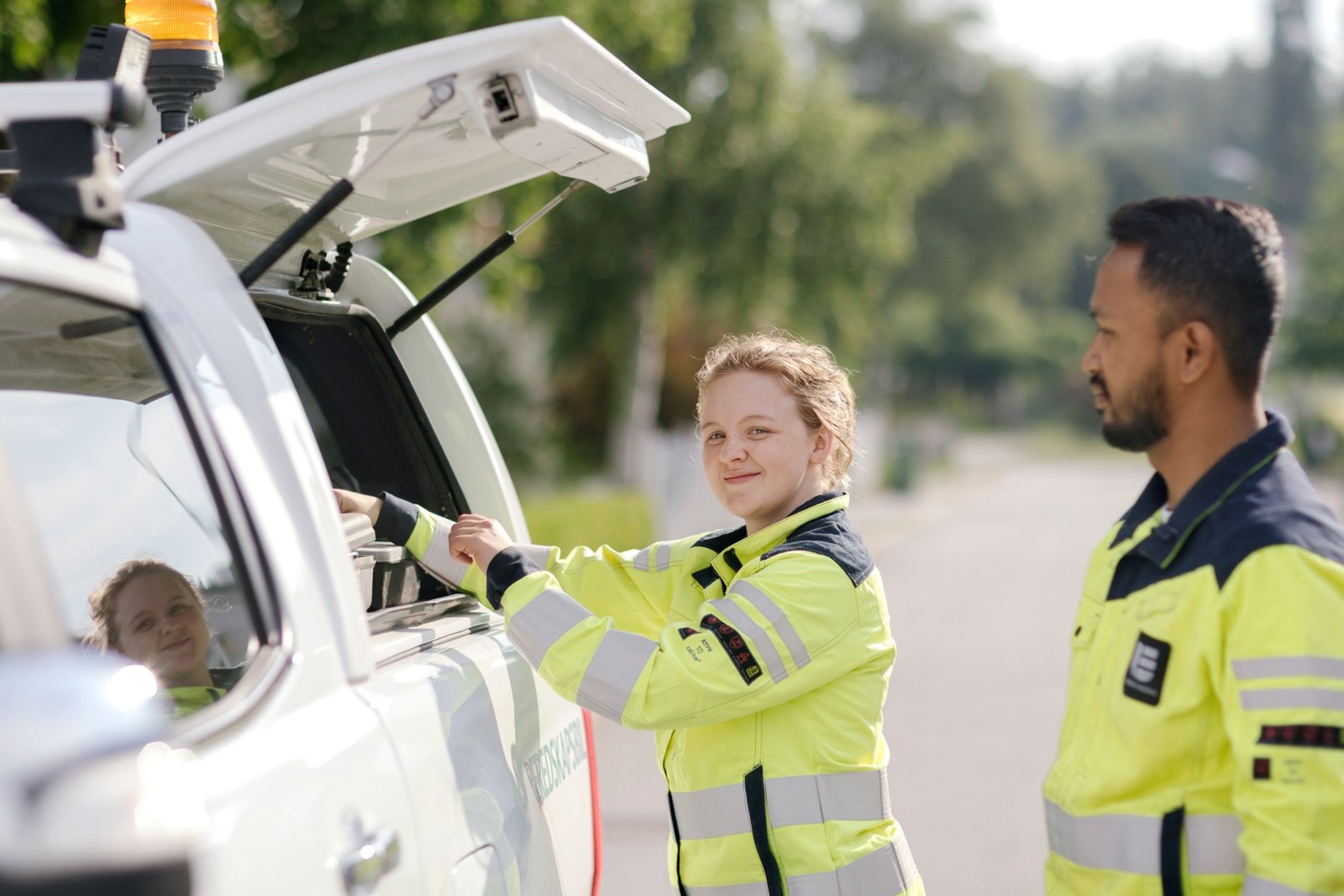Två personer i varseljackor intill en beredskapsbil
