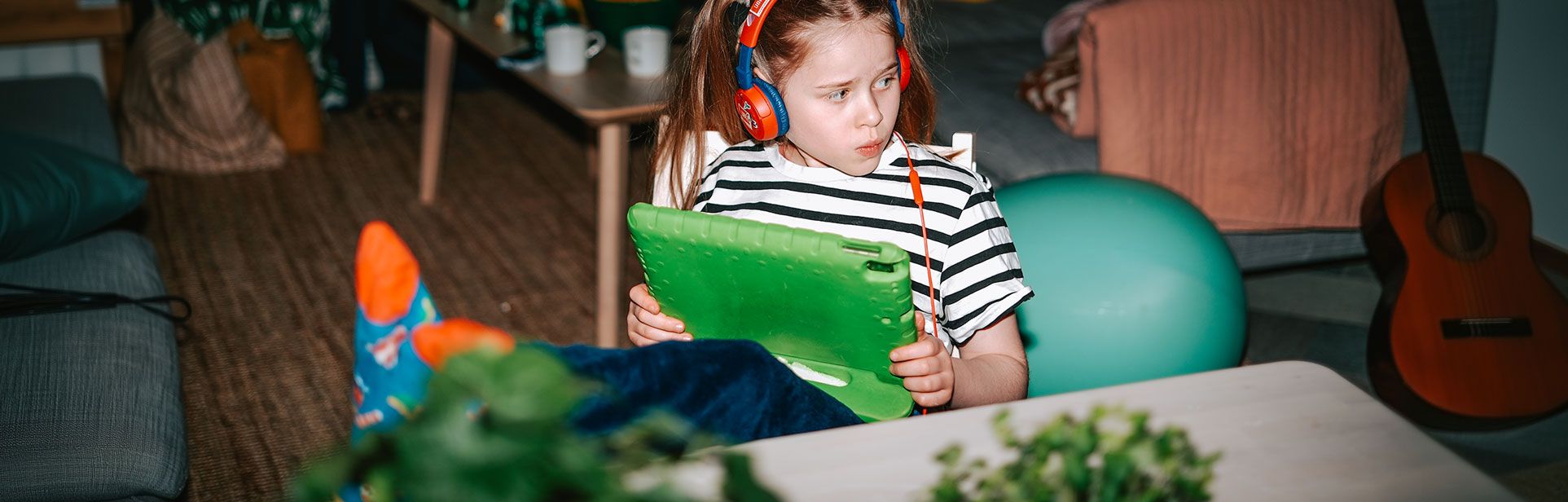 Person som sitter med fötterna på bordet och kollar på en läsplatta.