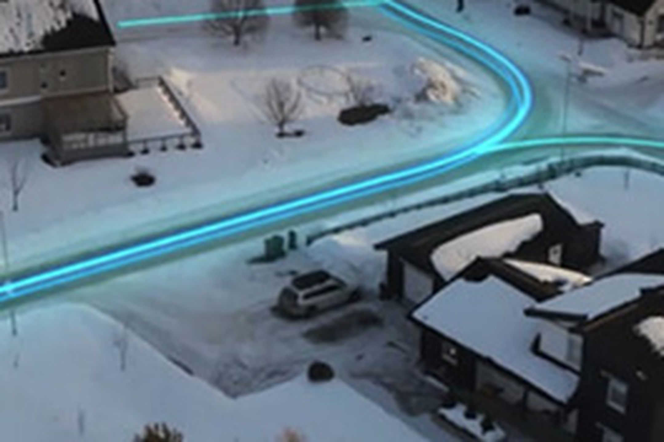 En bild över en vintrig kvartersgata där en illustration av en neonblå signal som löper längs vägarna