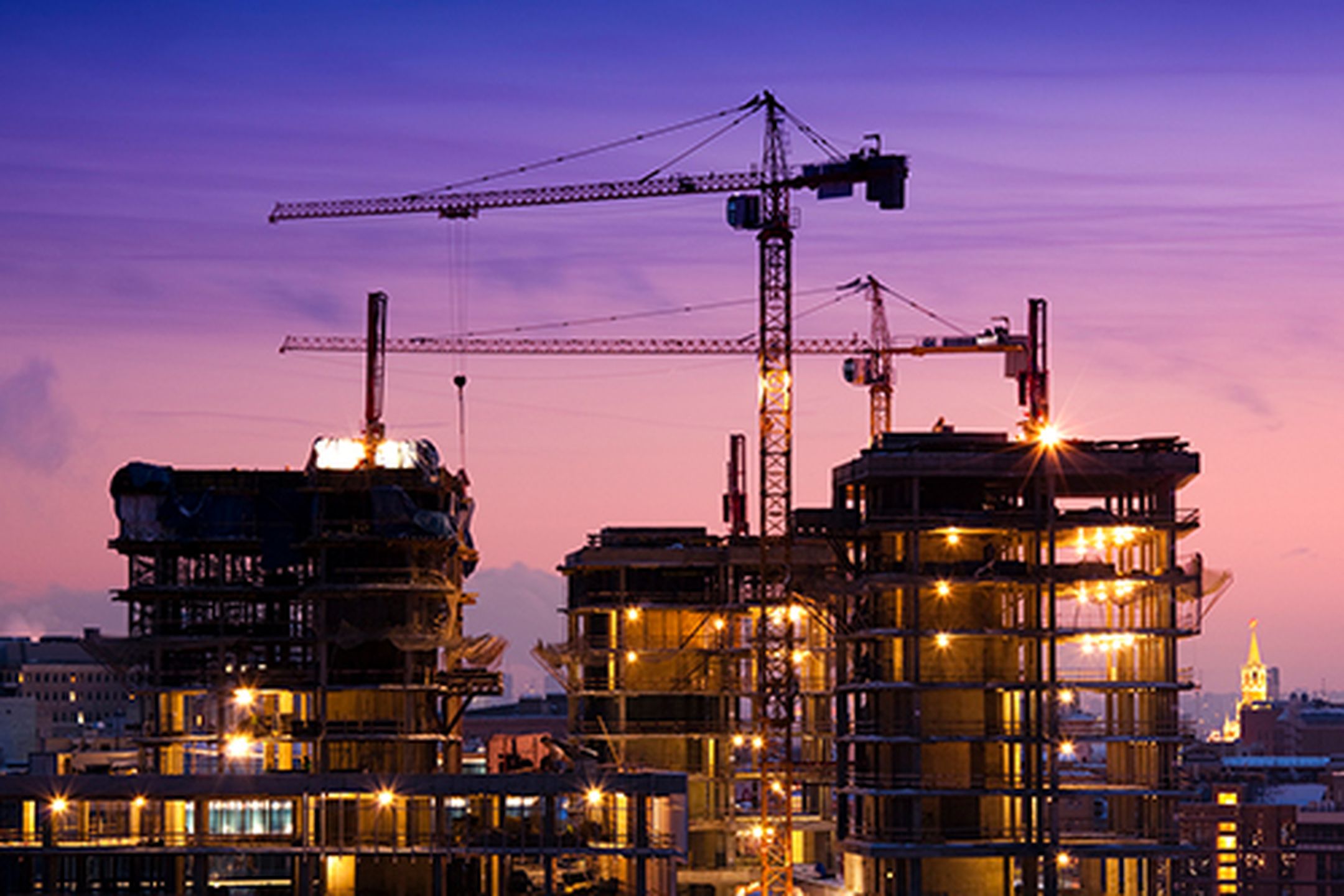 Vy över byggarbete av flerfamiljshus med lyftkranar intill