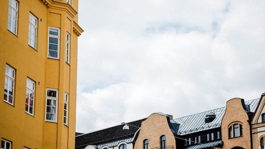 Hustak och fasad mot molnig himmel